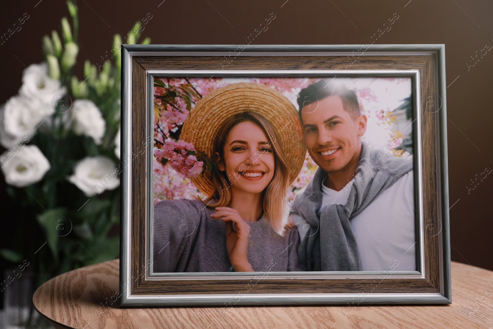 Photo of Framed photo of happy couple on wooden table indoors