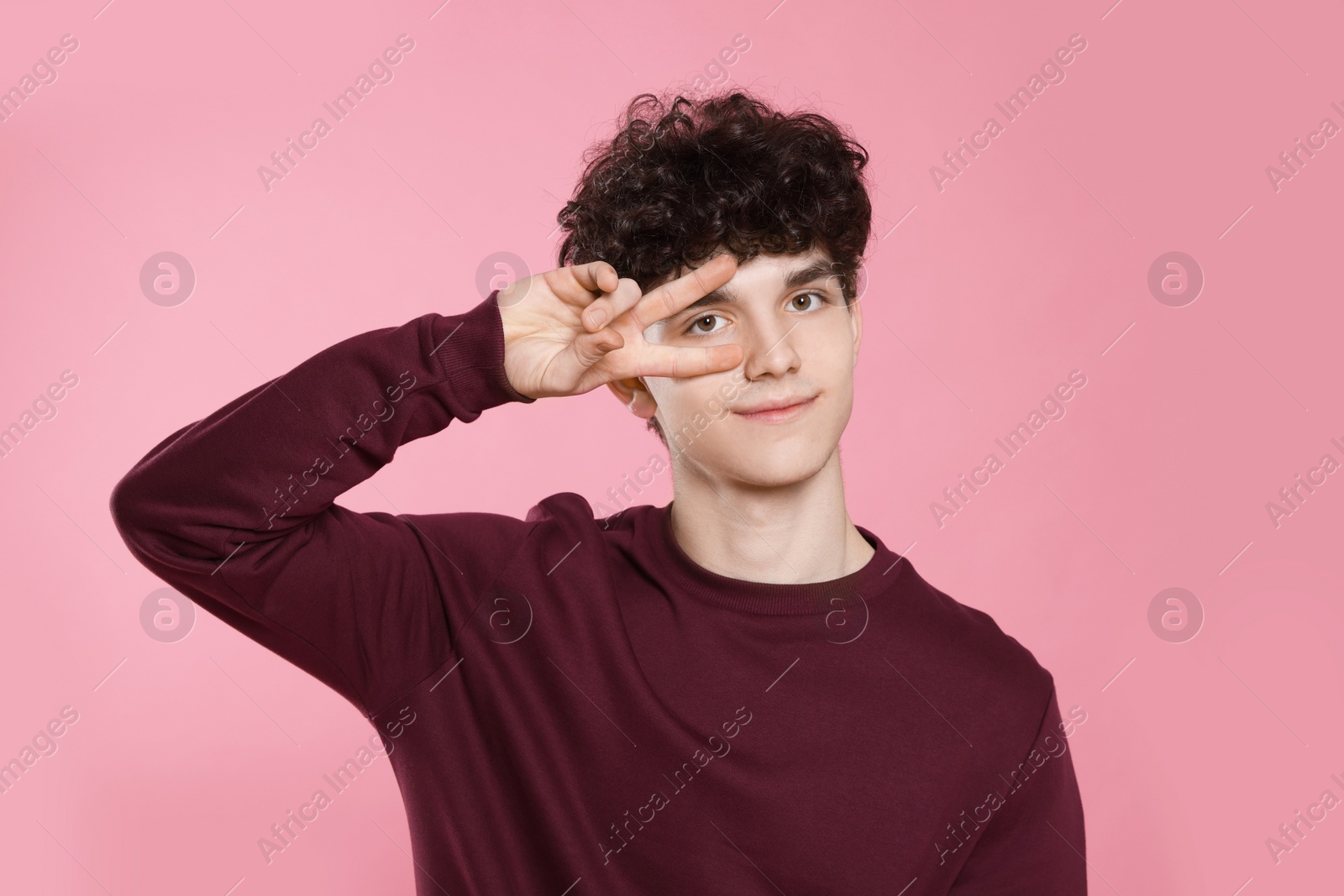 Photo of Portrait of cute teenage boy on pink background