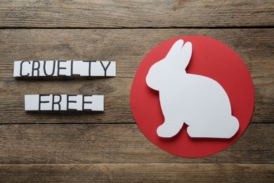 Cards with text Cruelty Free and figure of rabbit on wooden table, flat lay. Stop animal tests