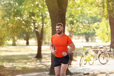 Photo of Young man running in park on sunny day