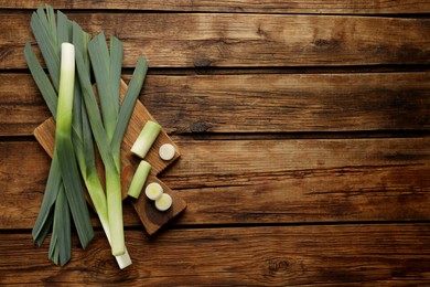 Fresh raw leeks on wooden table, top view. Space for text.