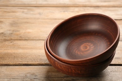 Photo of Beautiful empty clay bowls on wooden table