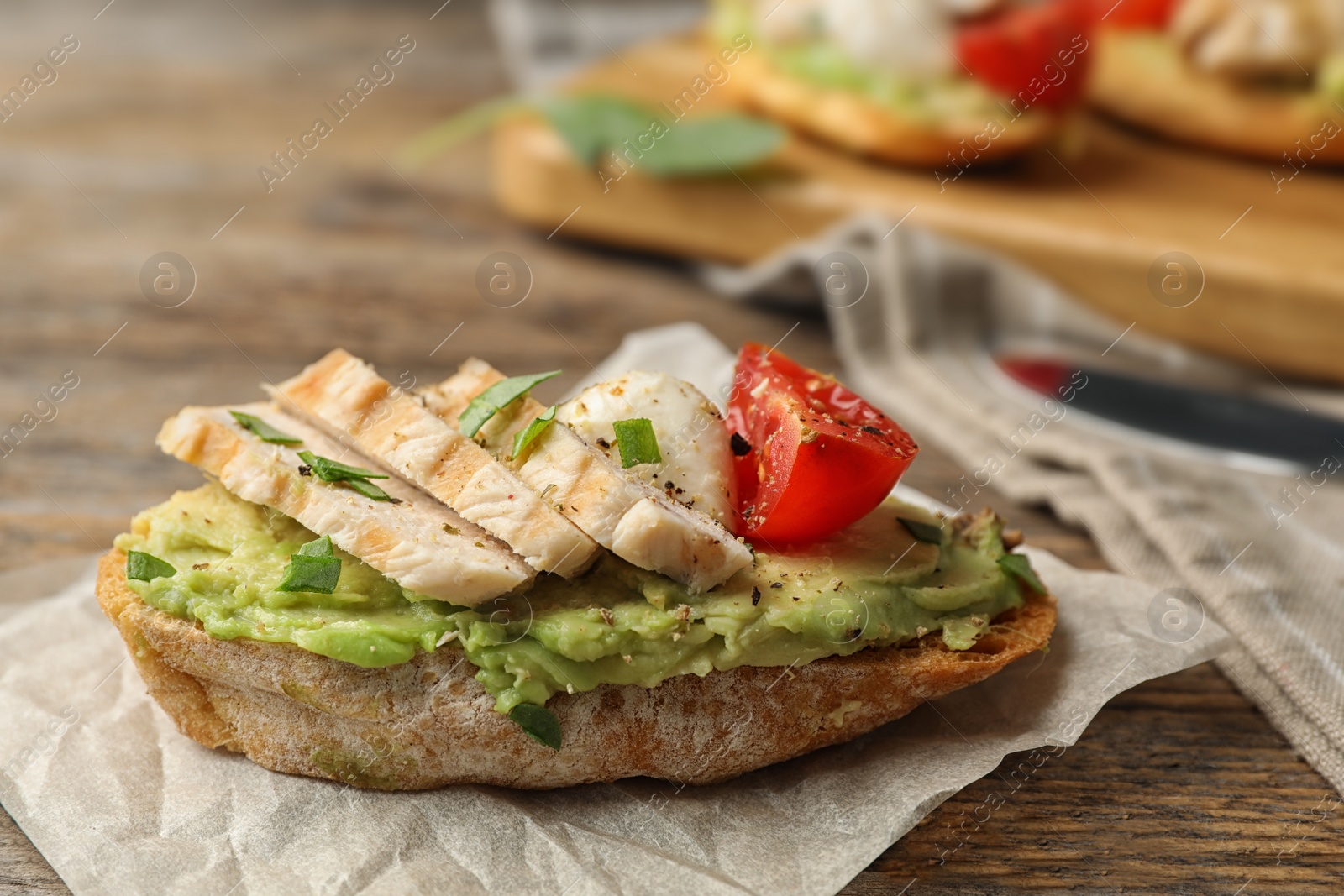 Photo of Delicious chicken bruschetta on wooden table, closeup