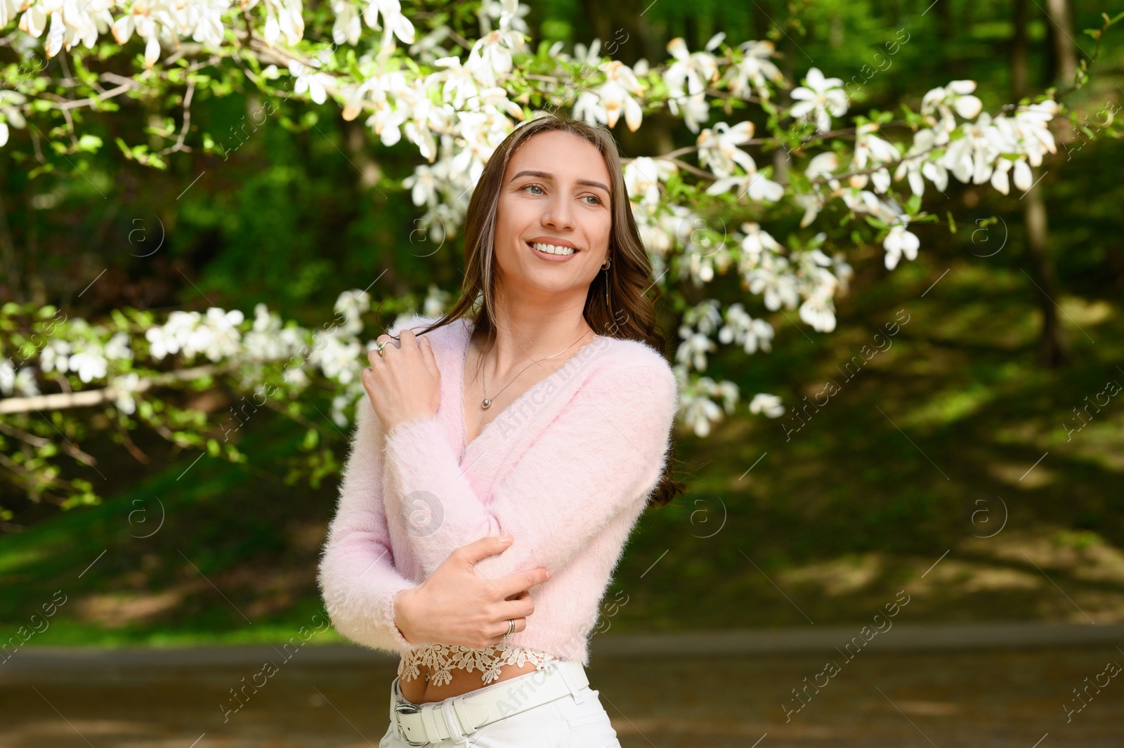 Photo of Beautiful young woman near blossoming tree on spring day