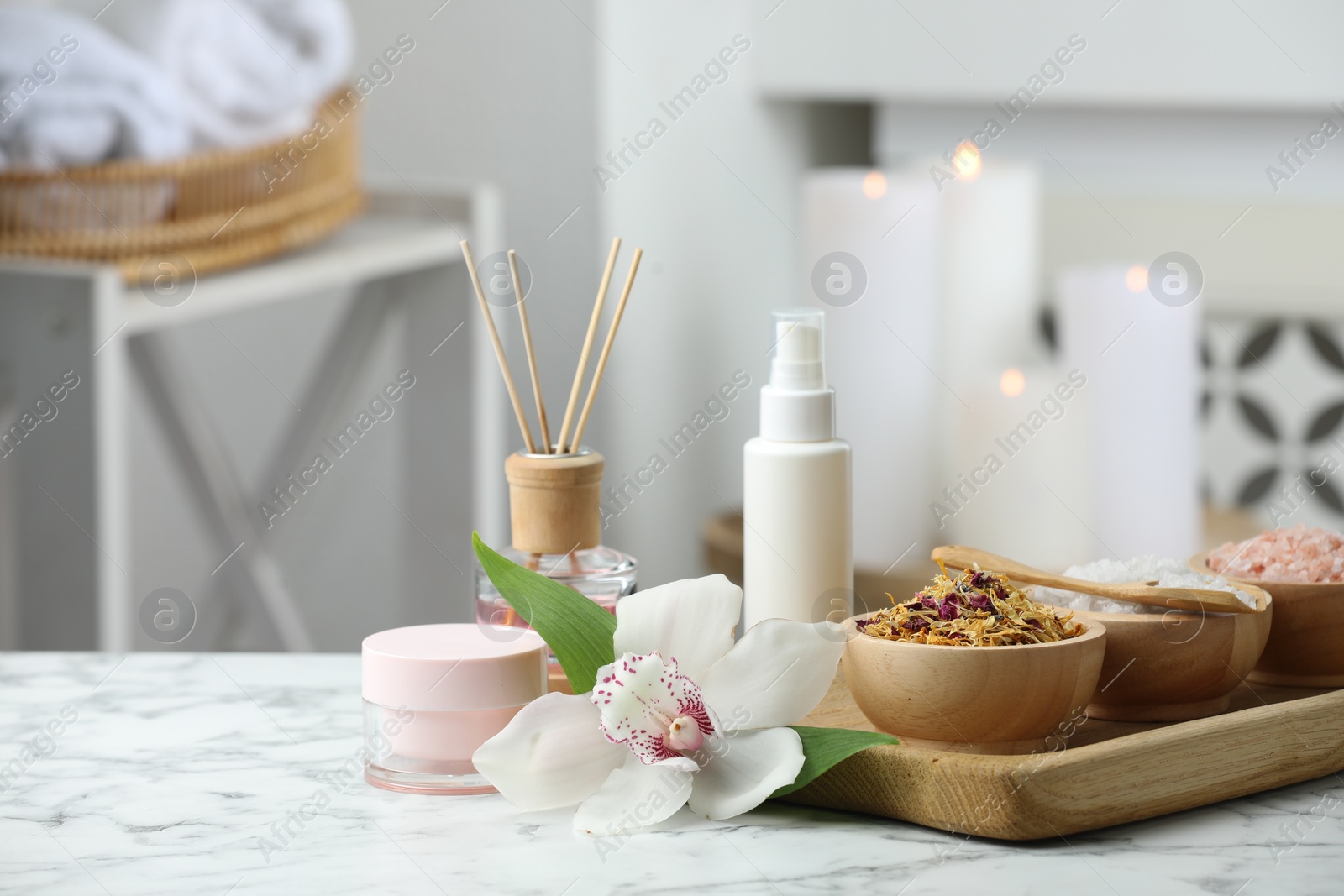 Photo of Beautiful composition with different spa products and orchid flower on white marble table indoors. Space for text