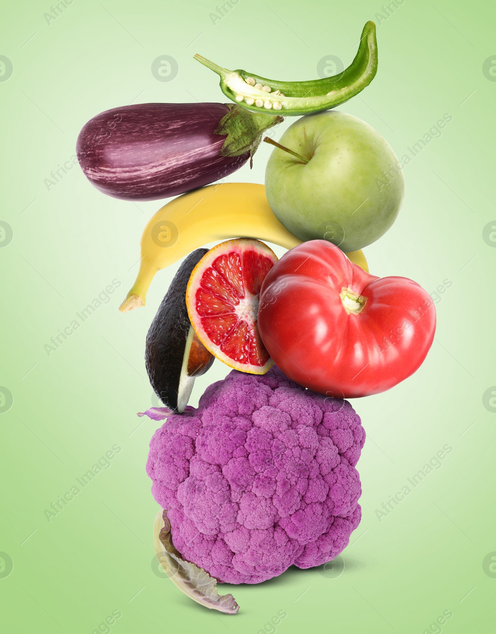 Image of Stack of different vegetables and fruits on pale light green background