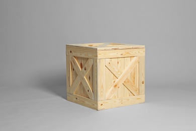 One closed wooden crate on grey background