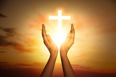 Image of Woman and cross silhouette outdoors, closeup view. Belief in Jesus Christ 