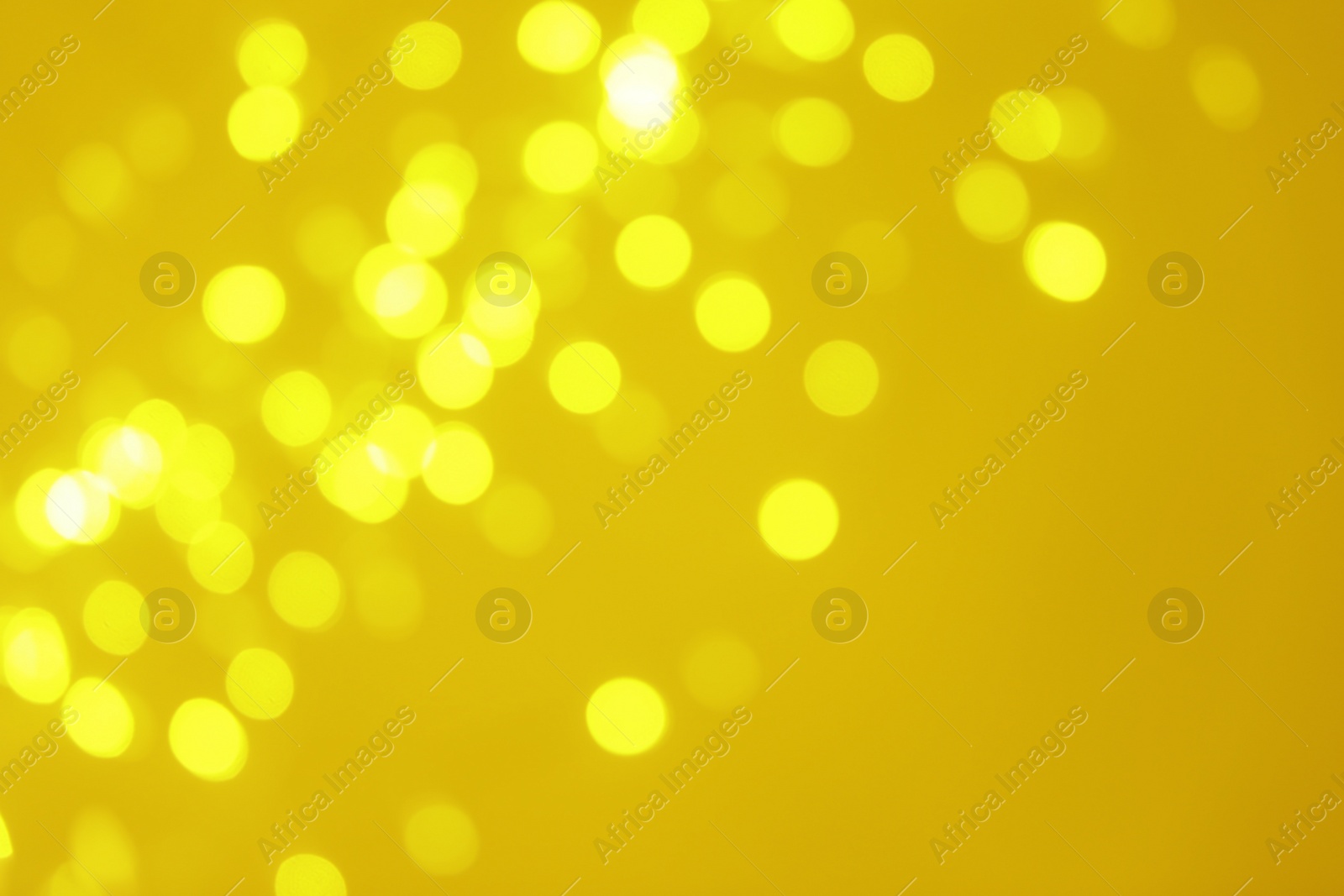 Photo of Blurred view of shiny gold lights. Bokeh effect
