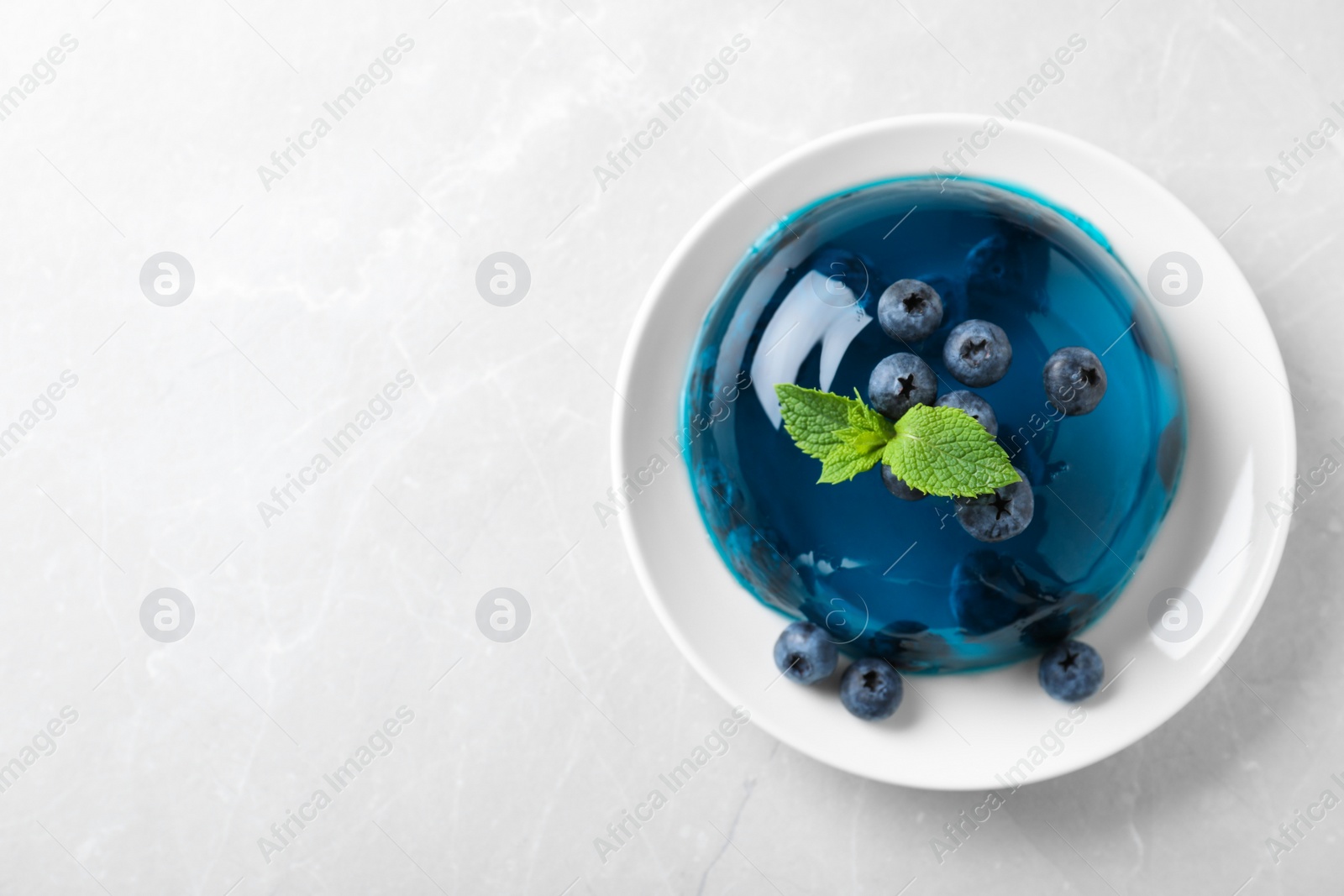 Photo of Delicious jelly with blueberries and mint on grey table, top view. Space for text