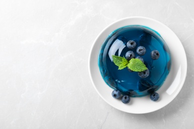 Photo of Delicious jelly with blueberries and mint on grey table, top view. Space for text