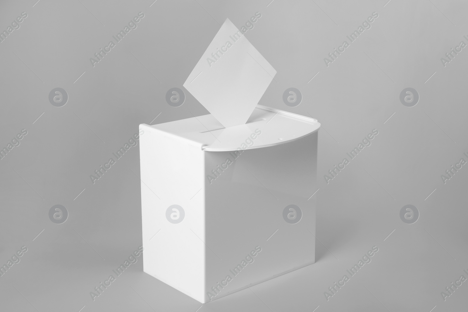 Photo of Ballot box with vote on light grey background. Election time