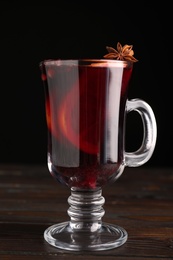Aromatic mulled wine in glass cup on wooden table