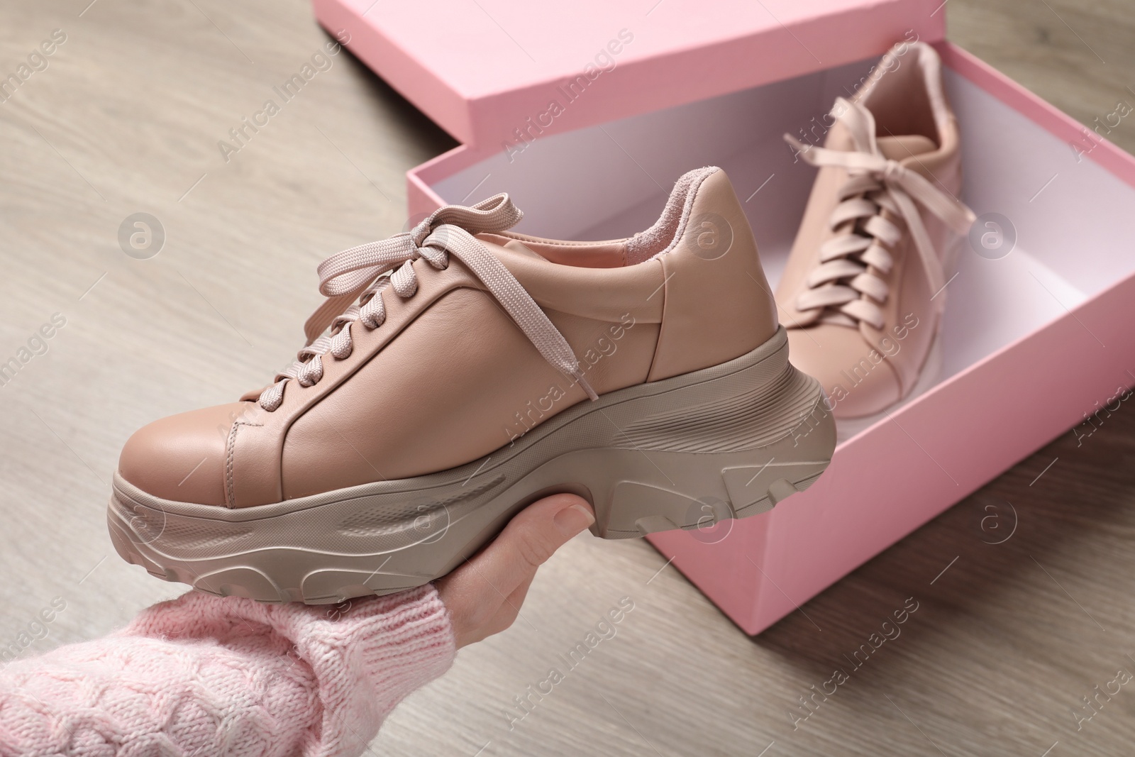 Photo of Woman holding stylish leather shoe indoors, closeup