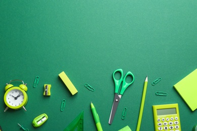 Bright school stationery on green background, flat lay. Space for text