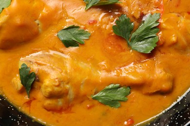 Photo of Tasty chicken curry with parsley, top view