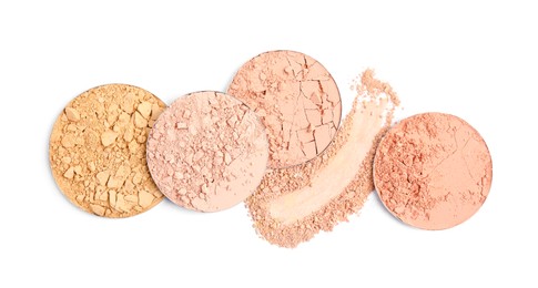 Different face powders and swatch on white background, top view