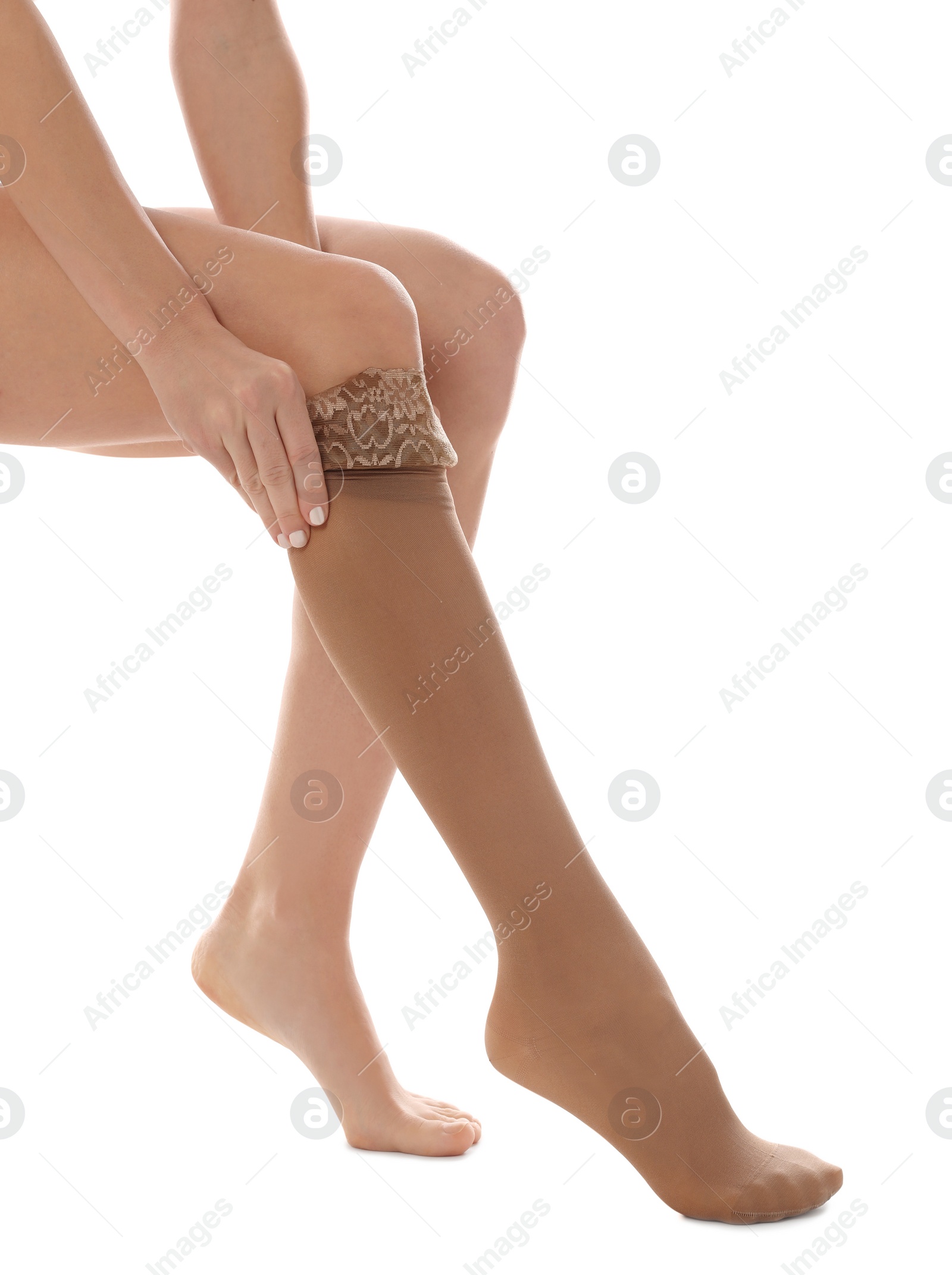 Photo of Woman putting on compression stocking against white background, closeup