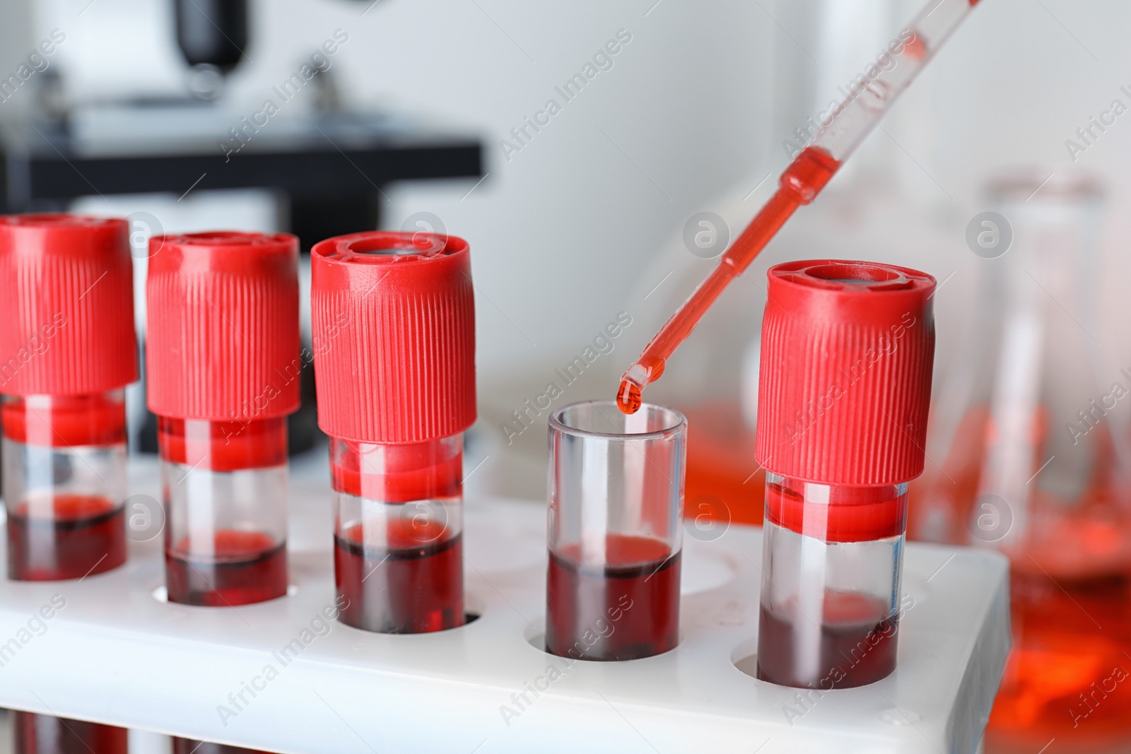 Image of Dripping sample from pipette into test tube, closeup. Laboratory analysis