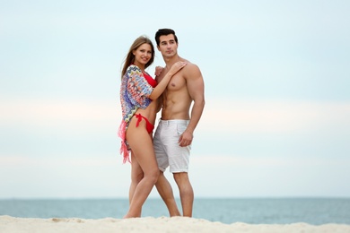 Happy young couple spending time together on sea beach