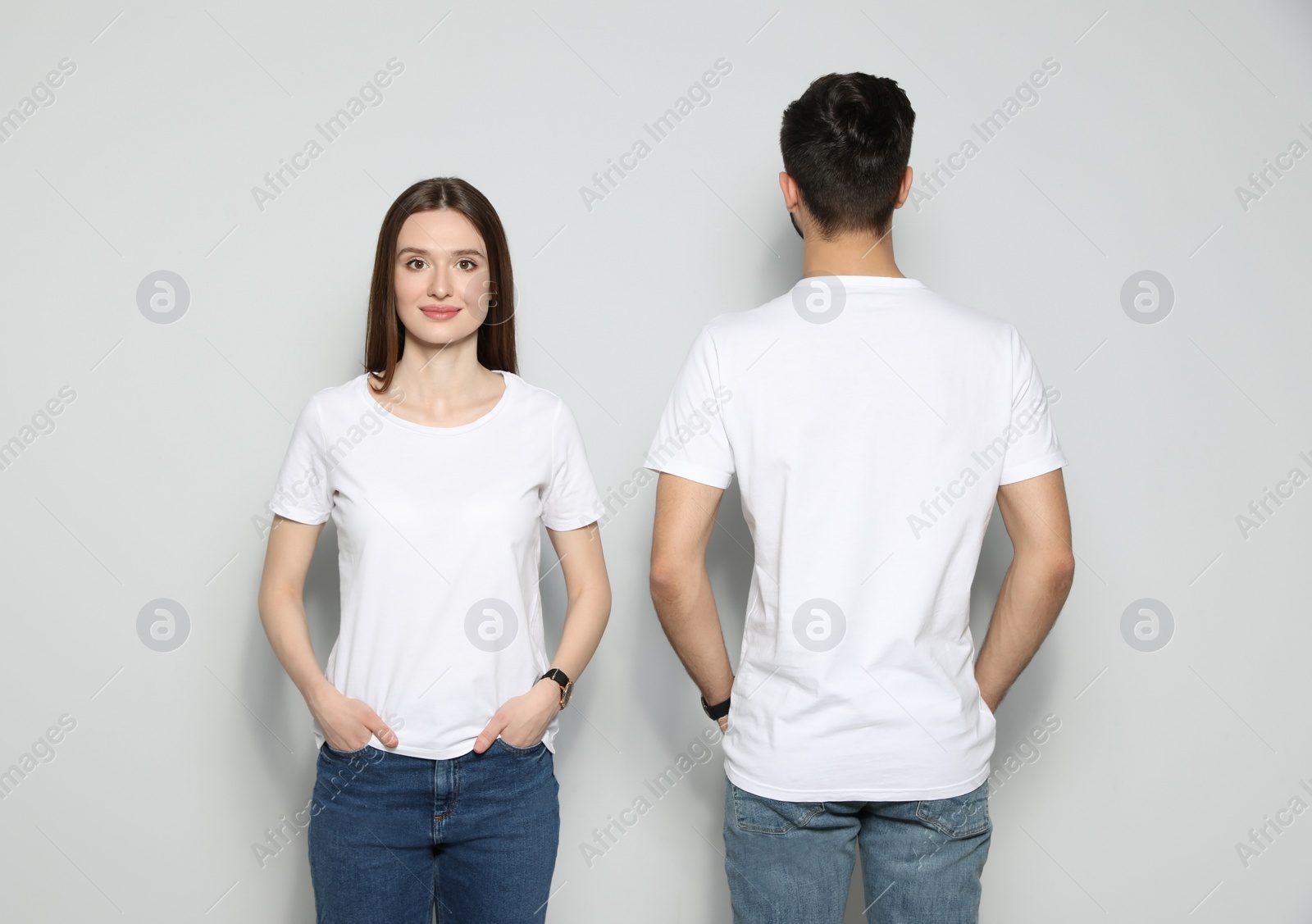 Photo of Young people in t-shirts on light background. Mock up for design