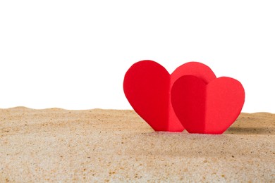 Photo of Honeymoon concept. Two red paper hearts and sand isolated on white