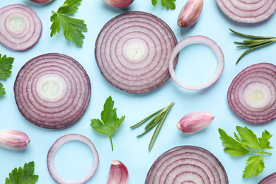 Flat lay composition with onion and spices on light blue background