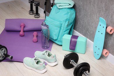 Photo of Many different sports equipment near grey wall indoors