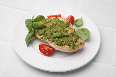 Delicious chicken breast with pesto sauce, tomatoes and basil on white table, closeup