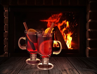 Image of Mulled wine on wooden table near fireplace