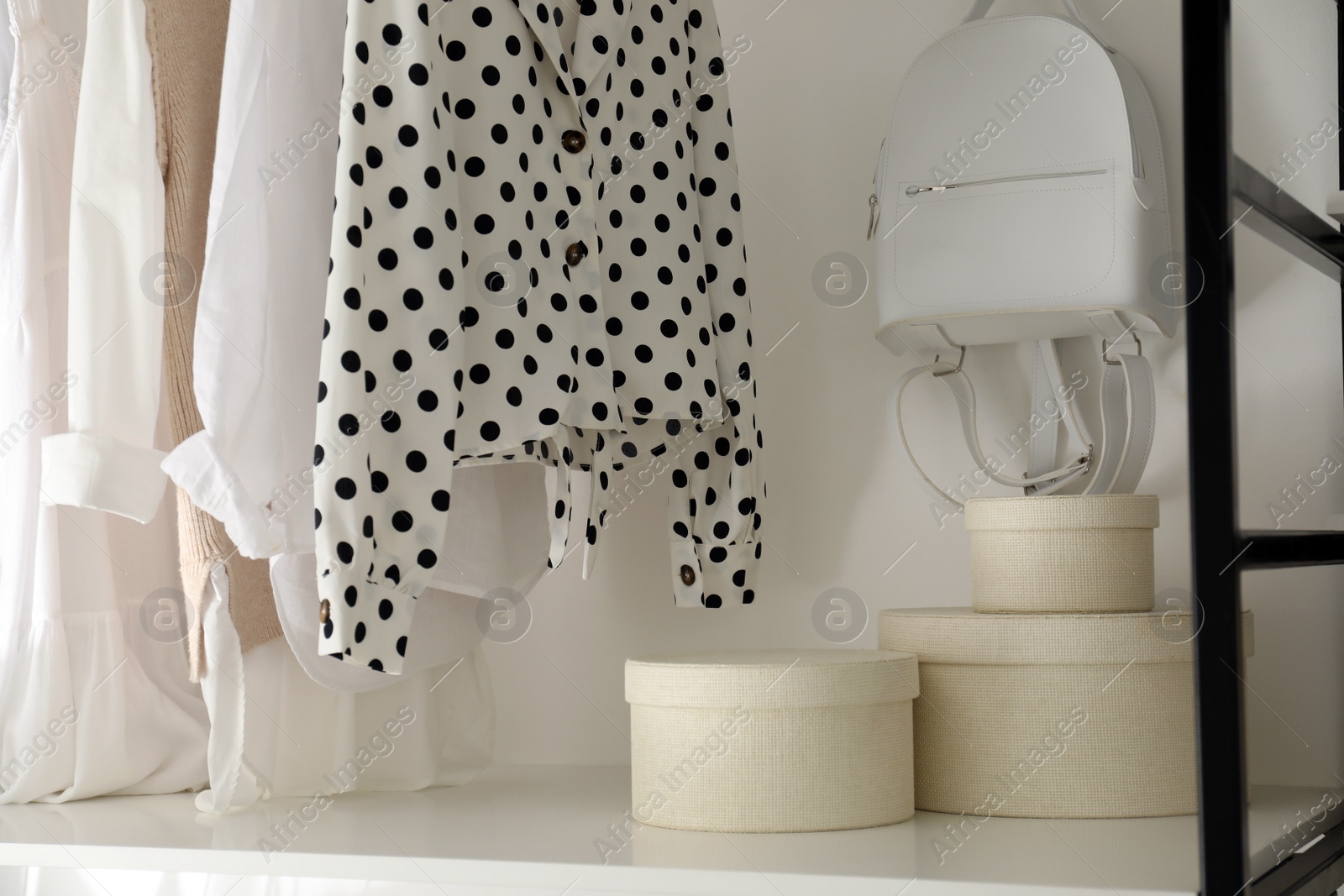 Photo of Storage rack with stylish women's clothes and accessories indoors