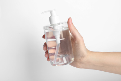 Photo of Woman holding antiseptic gel on white background, closeup