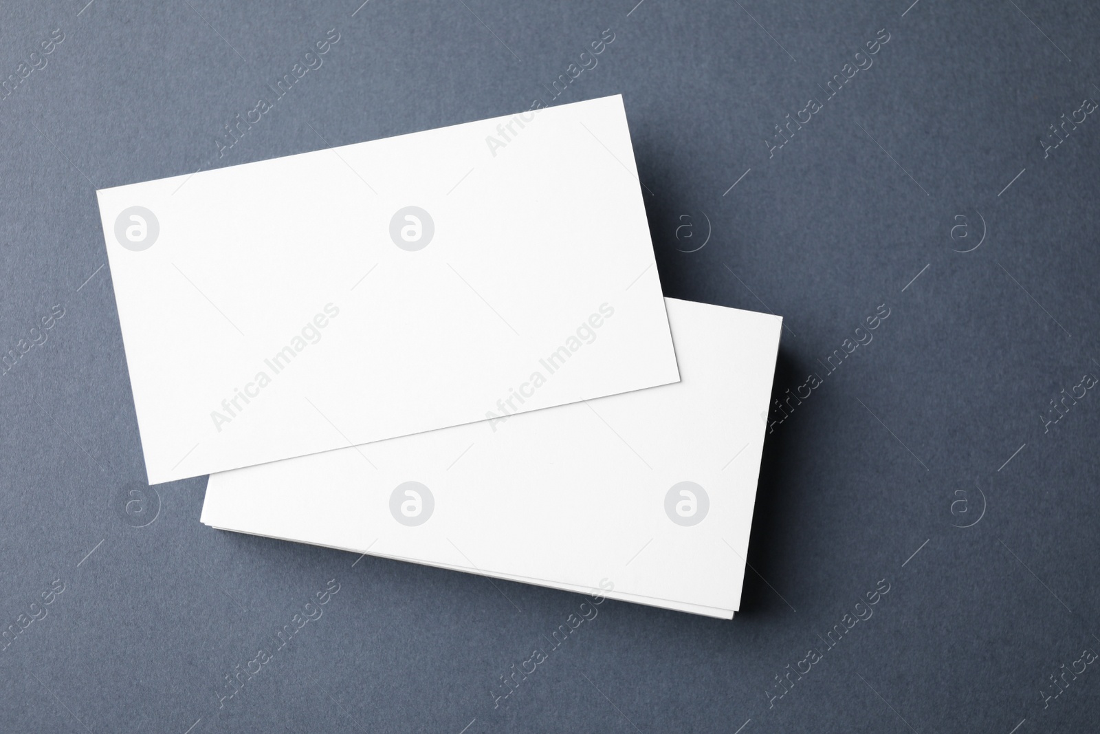 Photo of Blank business cards on dark grey background, top view. Mock up for design