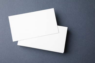 Blank business cards on dark grey background, top view. Mock up for design