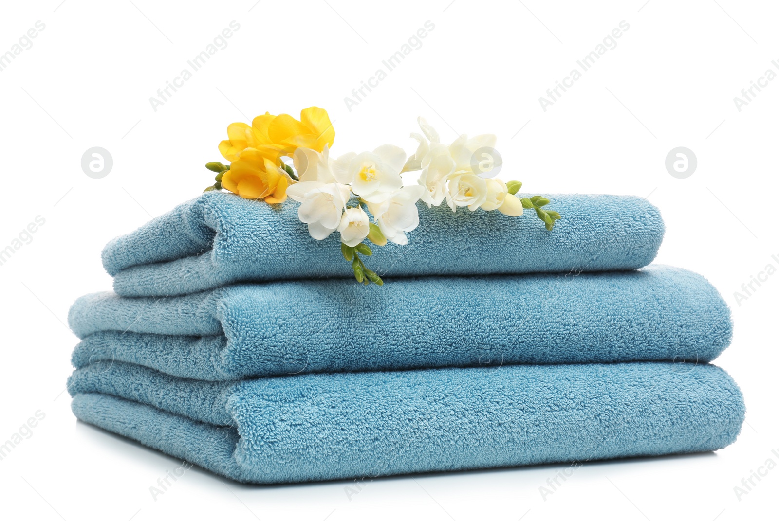 Photo of Stack of clean folded towels with flowers on white background