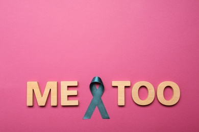 Photo of Phrase Me Too made of wooden letters and teal awareness ribbon on pink background, top view. Stop sexual assault