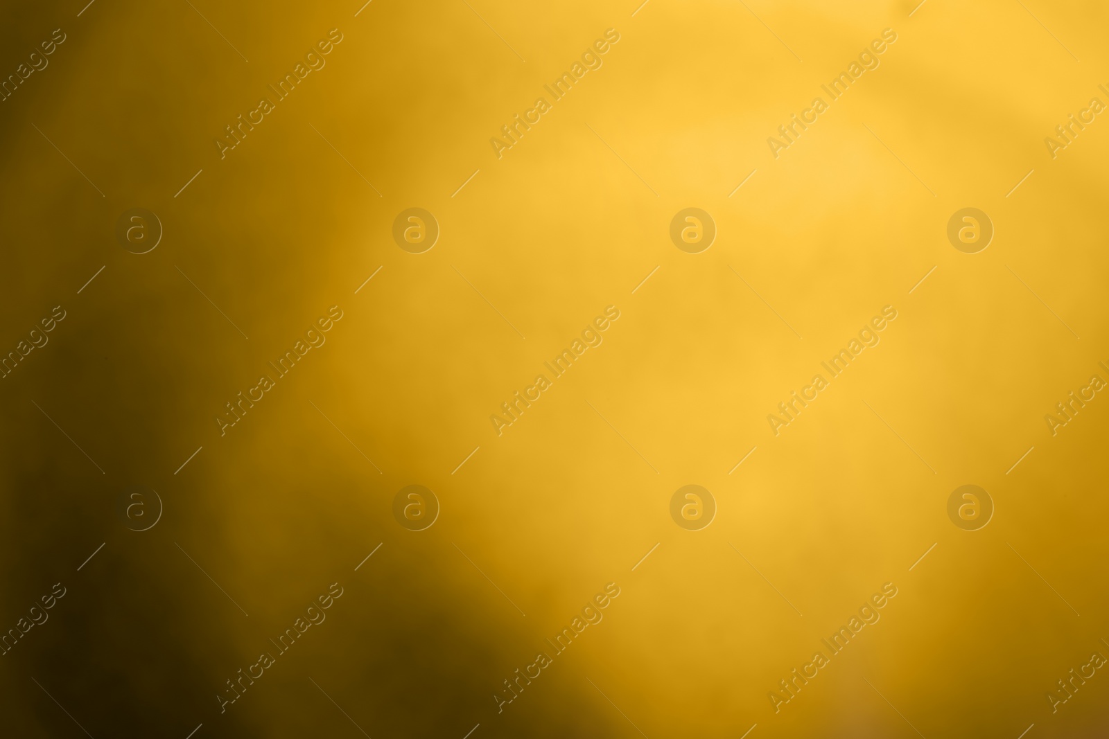 Photo of Blurred view of plain golden surface as background