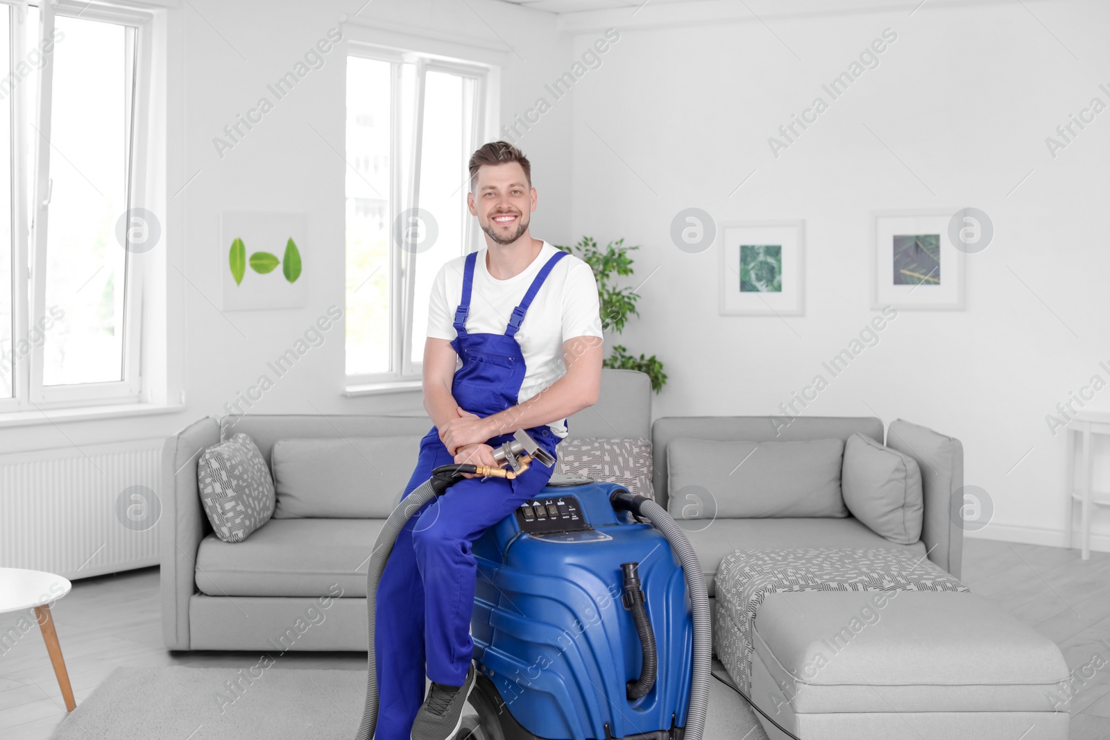 Photo of Dry cleaning worker with professional apparatus indoors