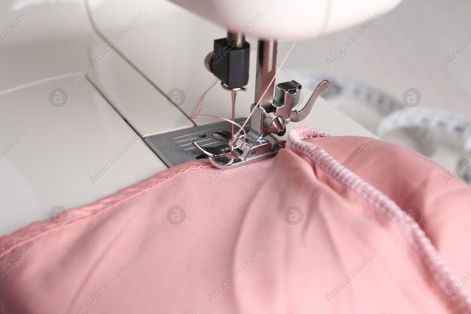 Photo of Sewing machine with color fabric on table, closeup