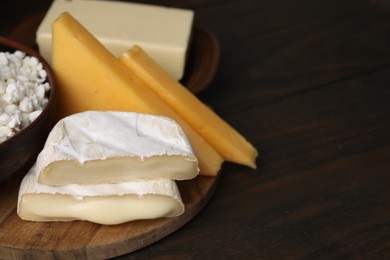 Dairy products. Different kinds of cheese and butter on wooden table, closeup. Space for text