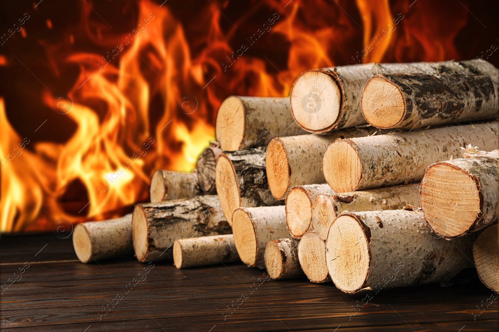 Image of Dry wood and burning fire on background. Cozy atmosphere