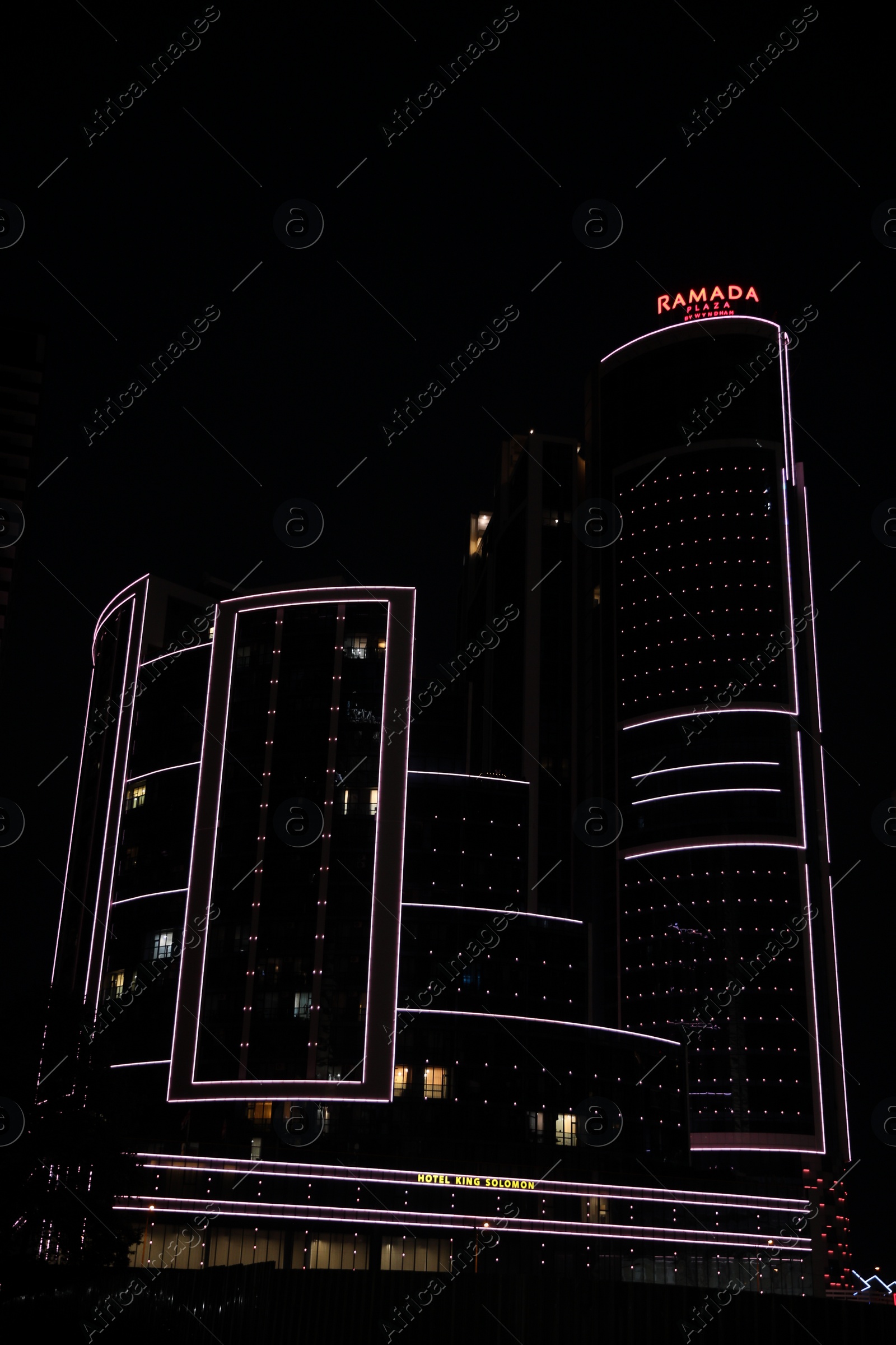 Photo of BATUMI, GEORGIA - JUNE 09, 2022: Night cityscape with illuminated building of Ramada Hotel