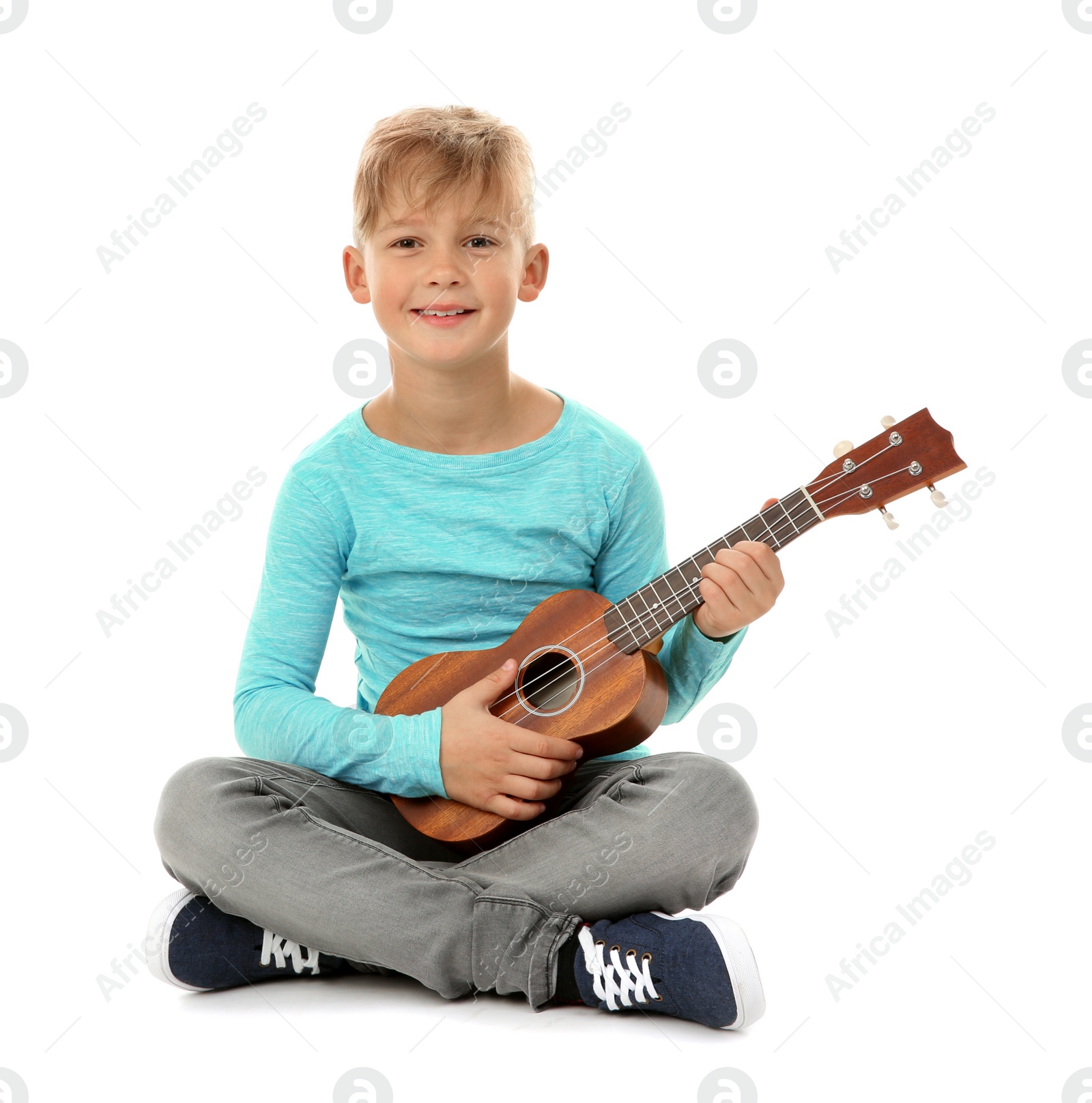 Photo of Little boy playing guitar isolated on white