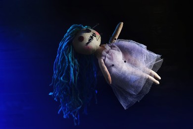 Image of Female voodoo doll with pins on dark blue background