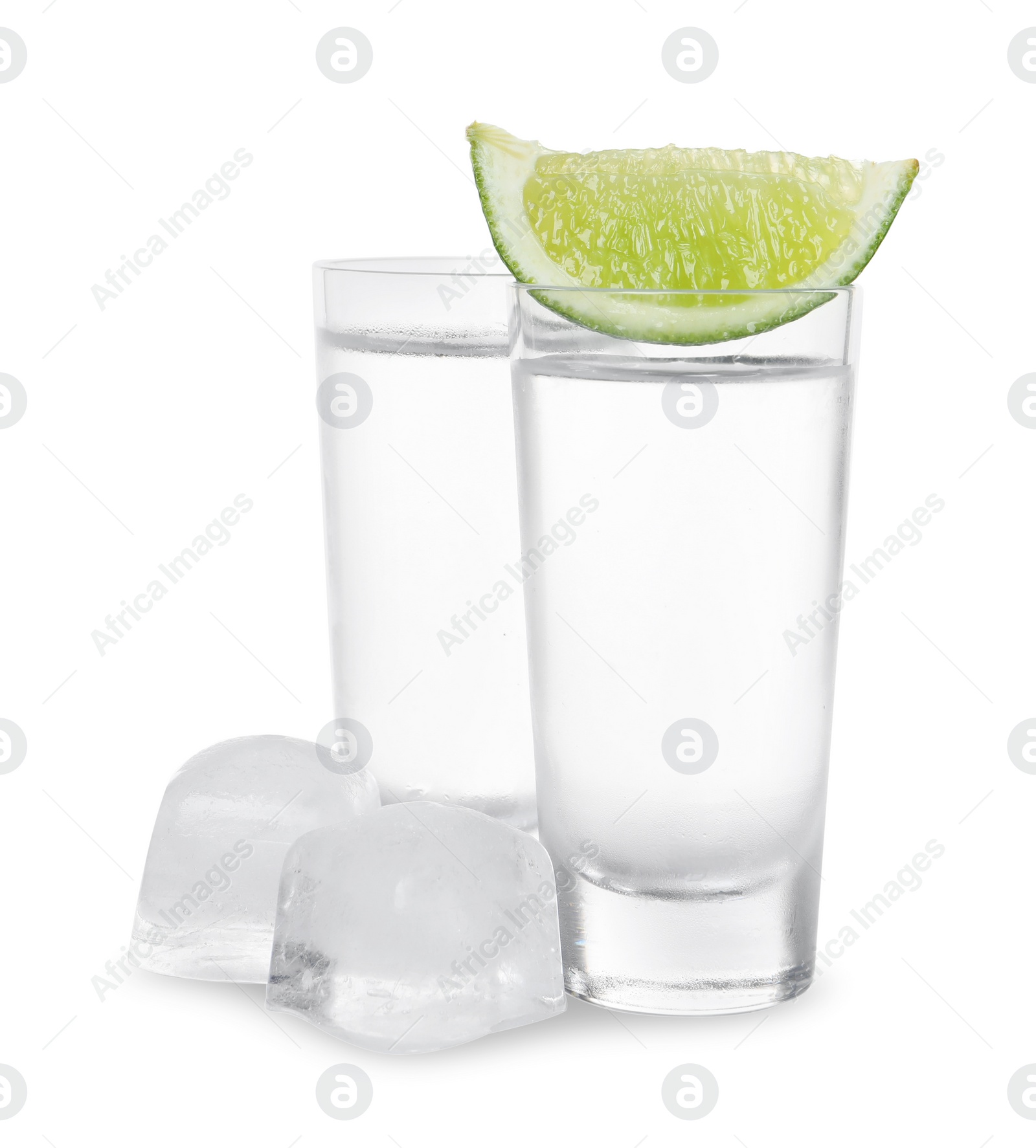 Photo of Shot glasses of vodka with lime slice and ice on white background