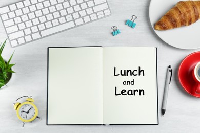 Lunch and Learn concept. Notebook, coffee, alarm clock, computer keyboard, croissant and stationery on white table, flat lay