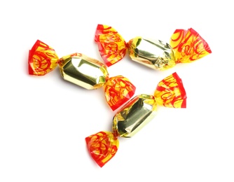 Delicious candies wrapped in foil on white background, top view