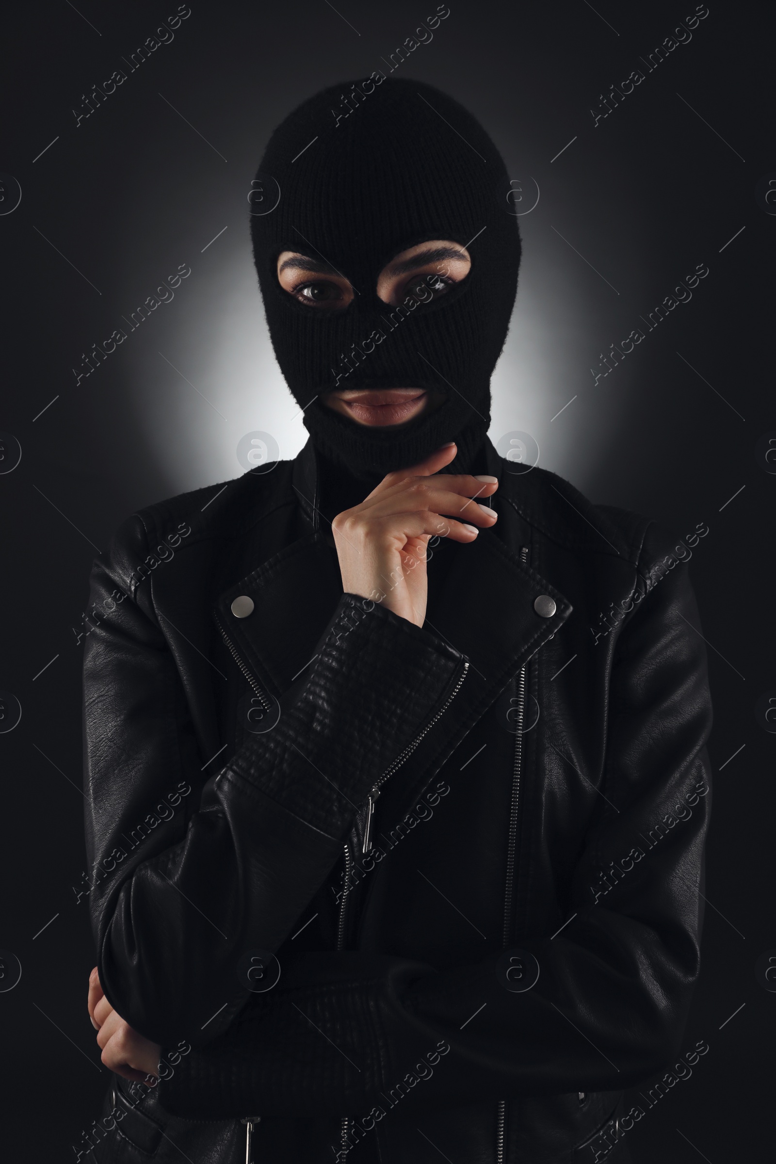 Photo of Woman wearing knitted balaclava on black background