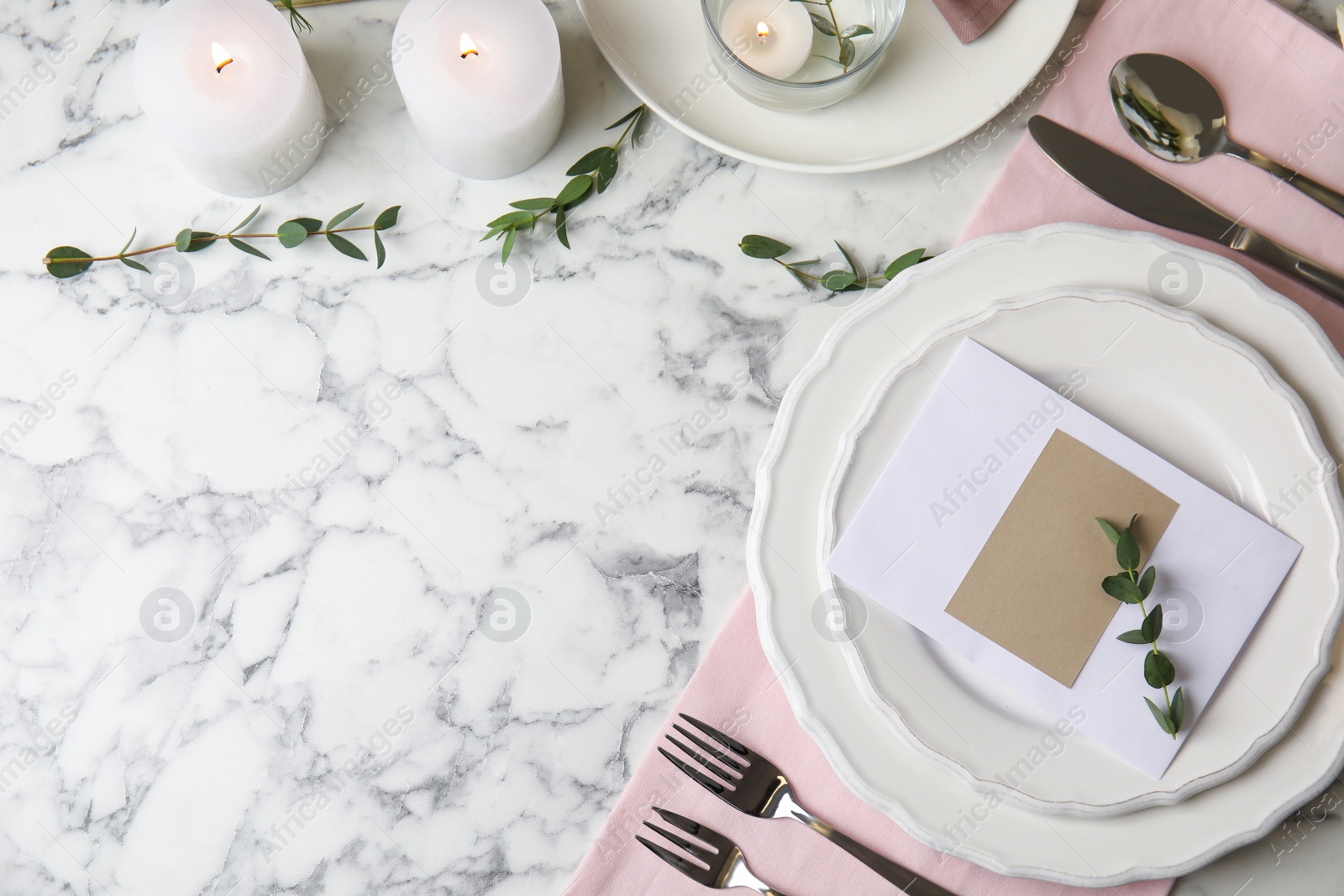 Photo of Elegant festive table setting with blank card on white marble background, flat lay. Space for text