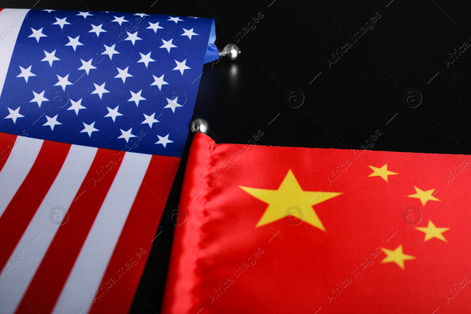 Photo of USA and China flags on black background, closeup